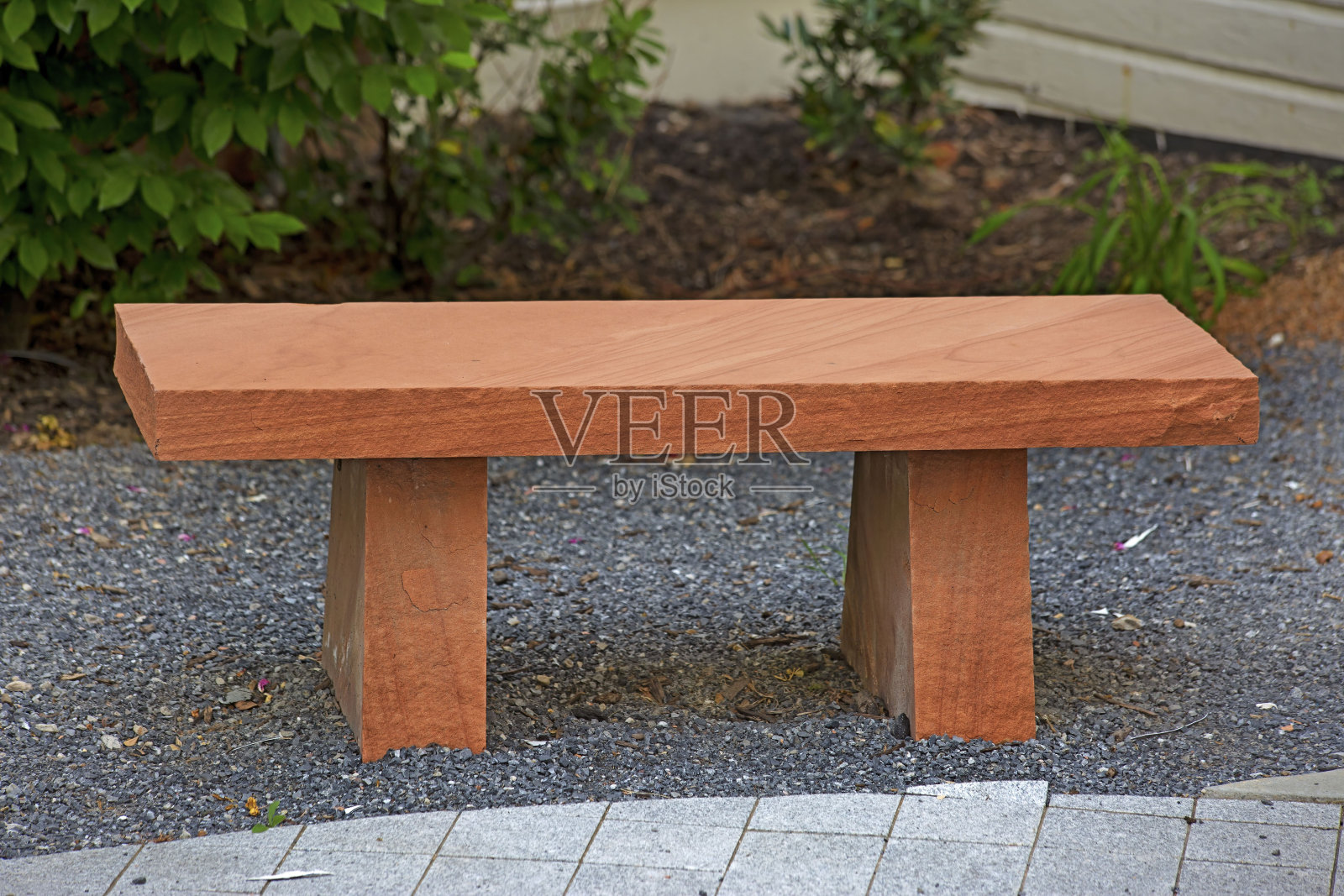 拍摄了房子附近的橙色石头制成的外部座椅。照片摄影图片