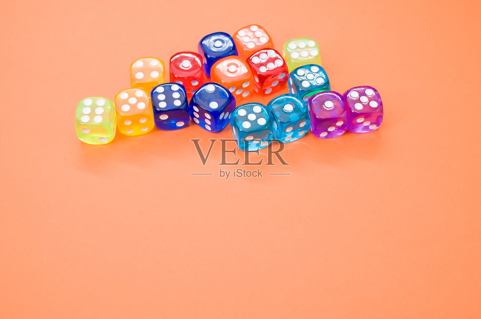 高角度拍摄彩色塑料骰子对橙色背景与文本空间照片摄影图片
