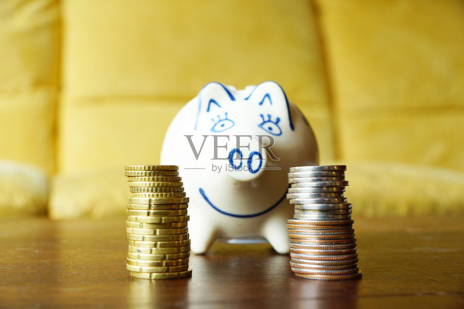 特写镜头是木桌上成堆的欧洲硬币和一个存钱罐照片摄影图片