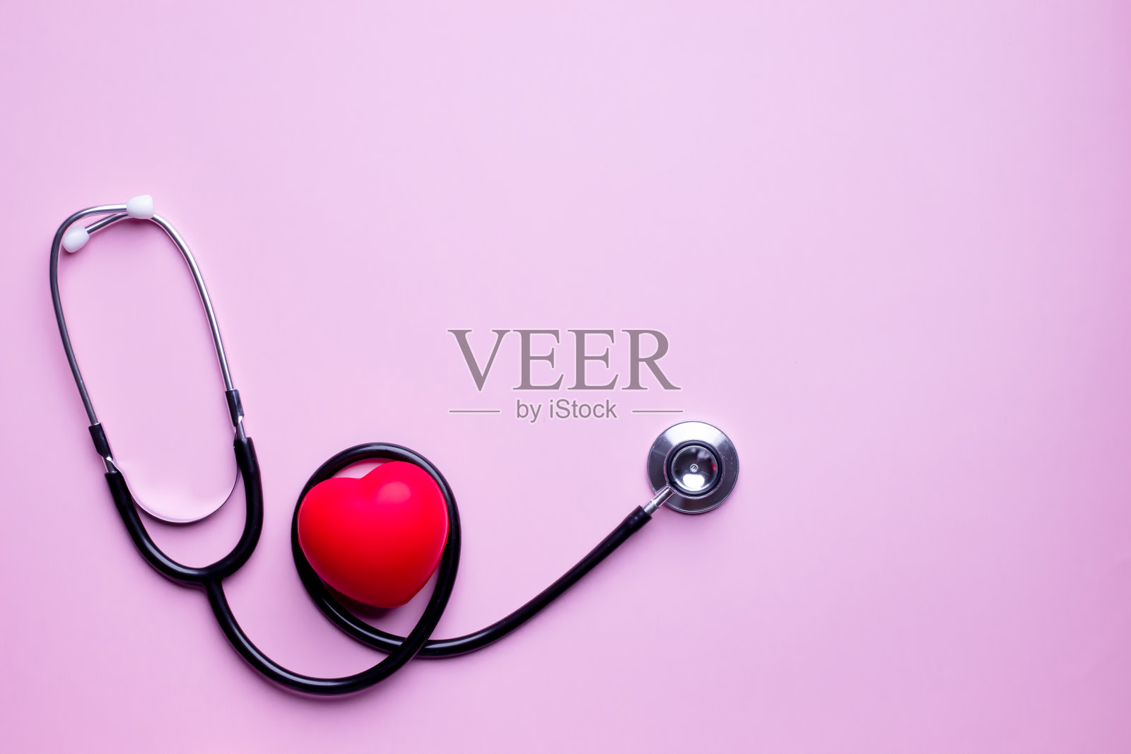 听诊器平铺以红色心跳检查。预防心脏病发作。一个保健概念。照片摄影图片