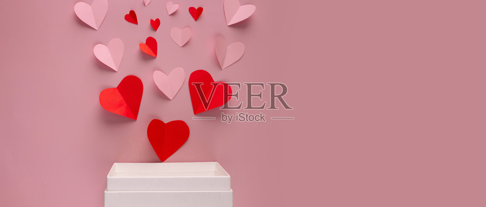 白色礼品盒边缘的粉色纸质心形情人节背景照片摄影图片