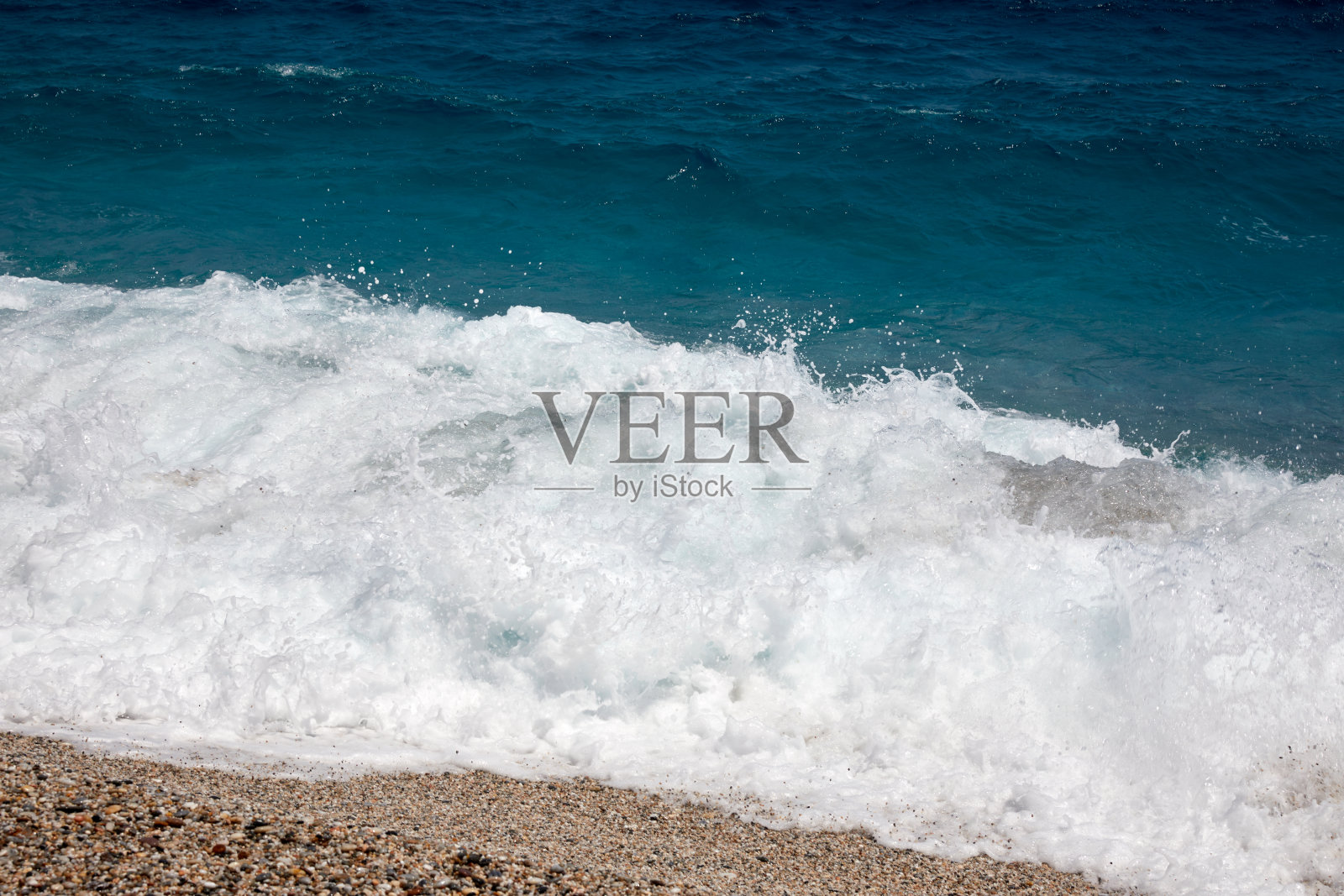 海浪拍击着岸边的泡沫照片摄影图片