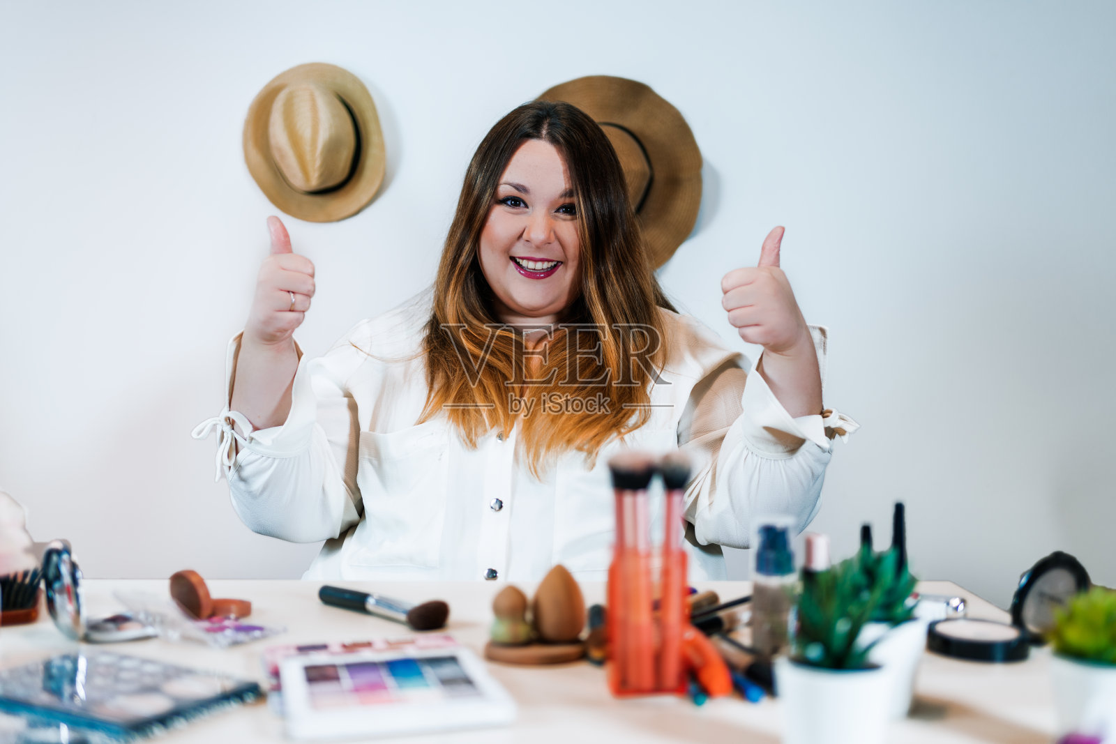 一个白人化妆师博主的女人看着相机微笑和捶打照片摄影图片