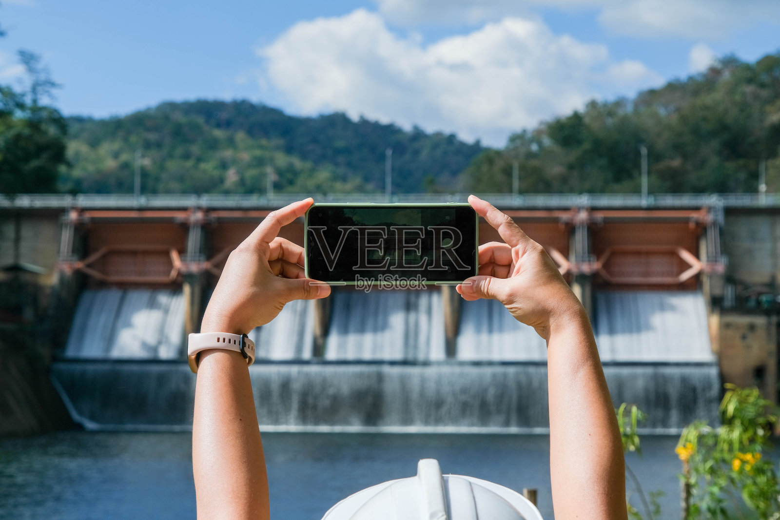 环境工程师使用手机拍照并记录分析大坝水污染物的数据。水与生态概念。照片摄影图片