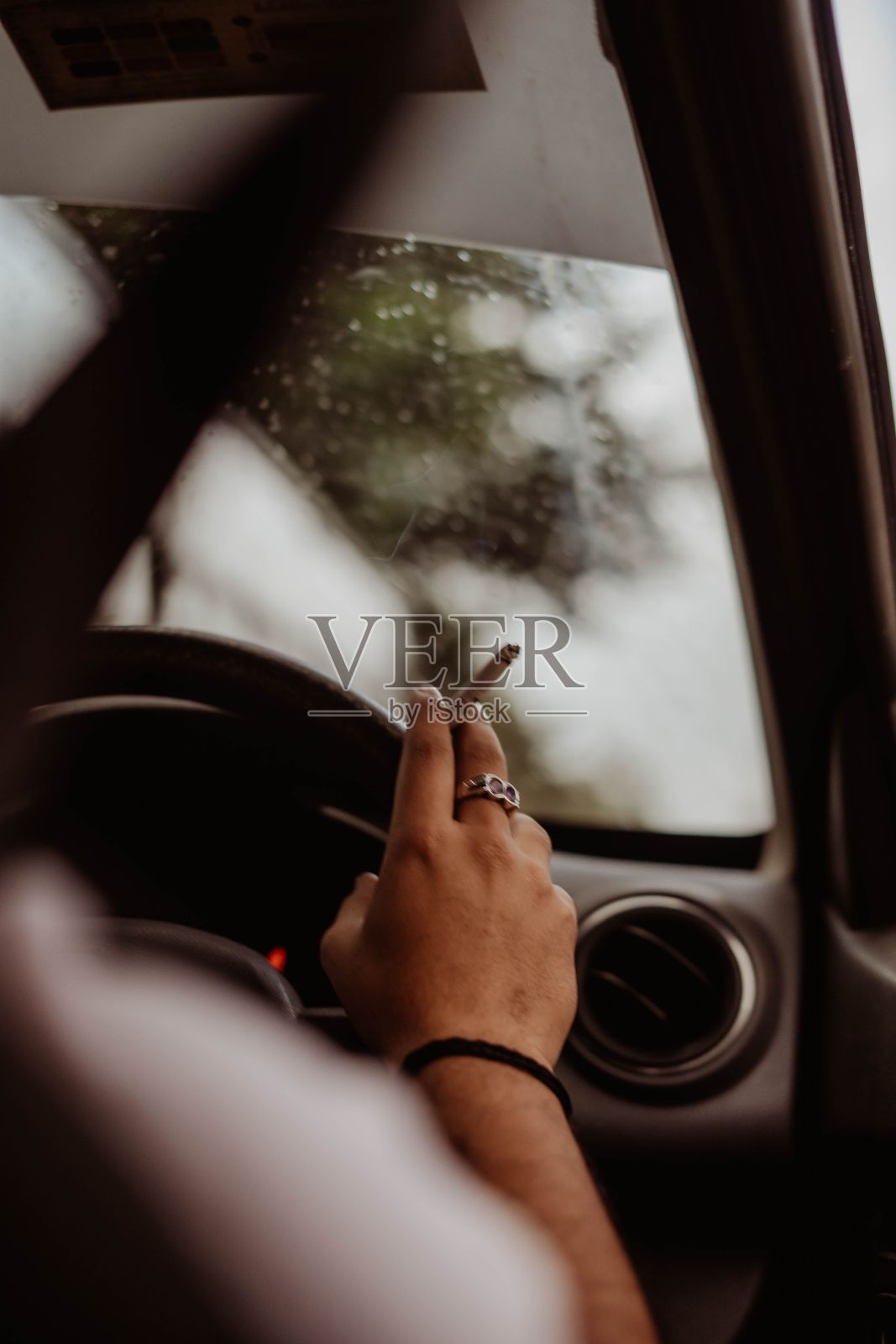 垂直镜头的一个司机的手与烟在它驾驶汽车照片摄影图片