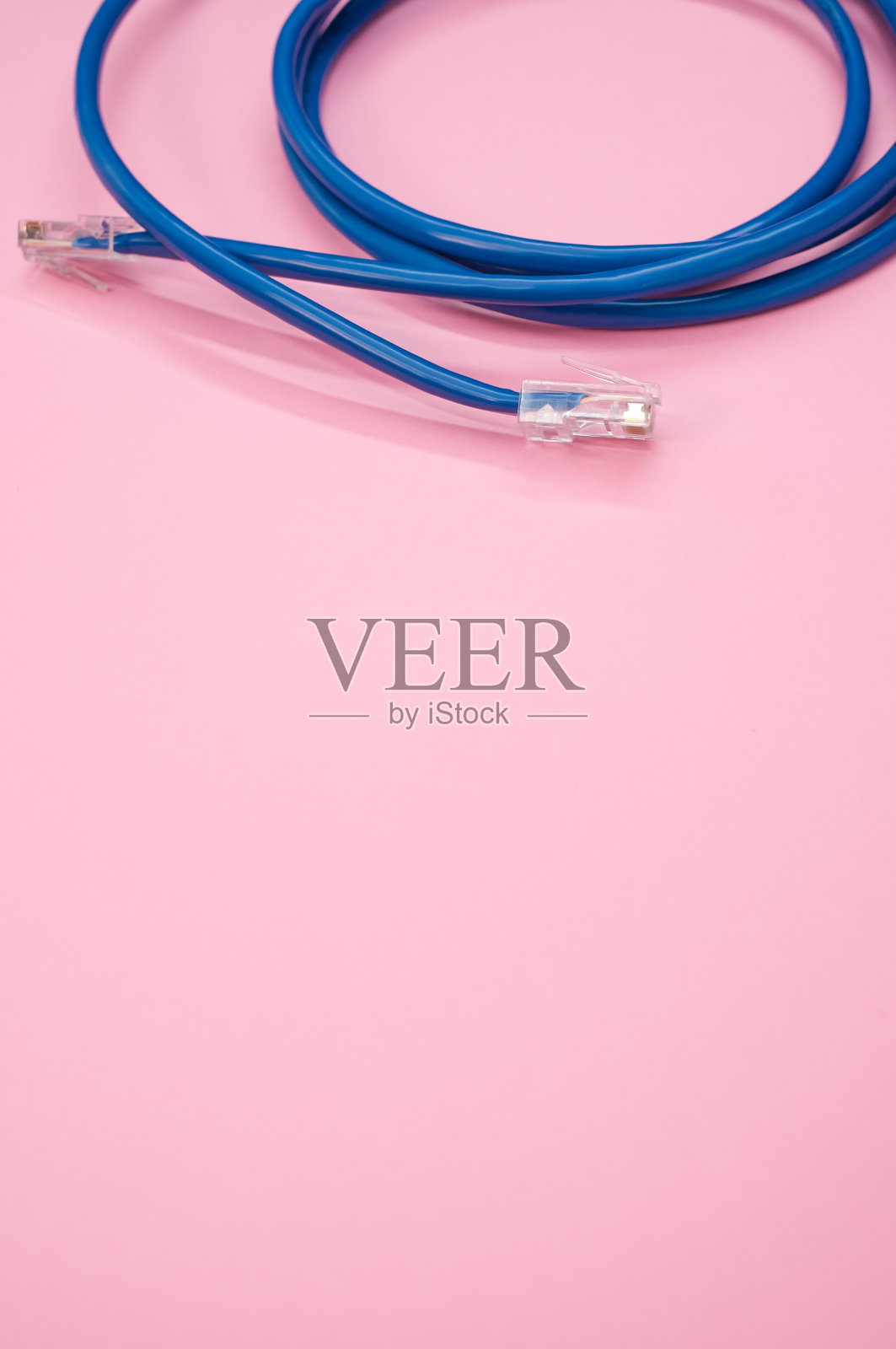 垂直拍摄的蓝色局域网电缆孤立在粉红色的背景照片摄影图片