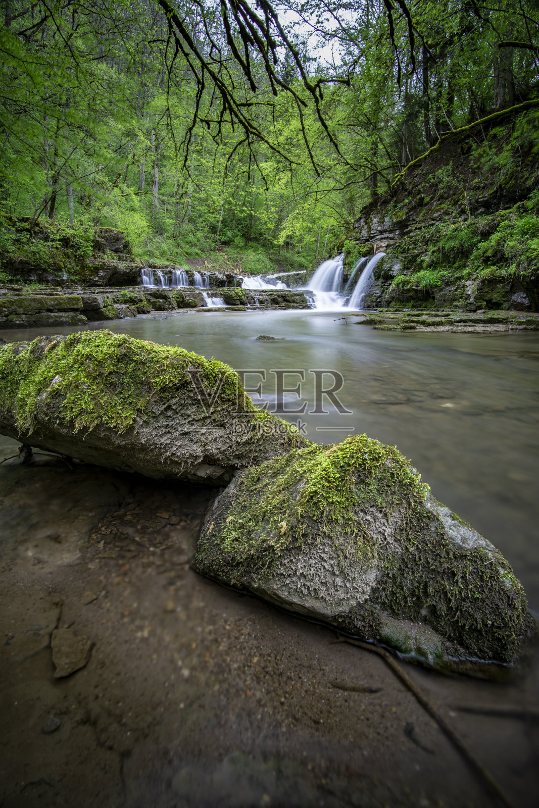 美丽的瀑布，清澈的水流在森林中央照片摄影图片
