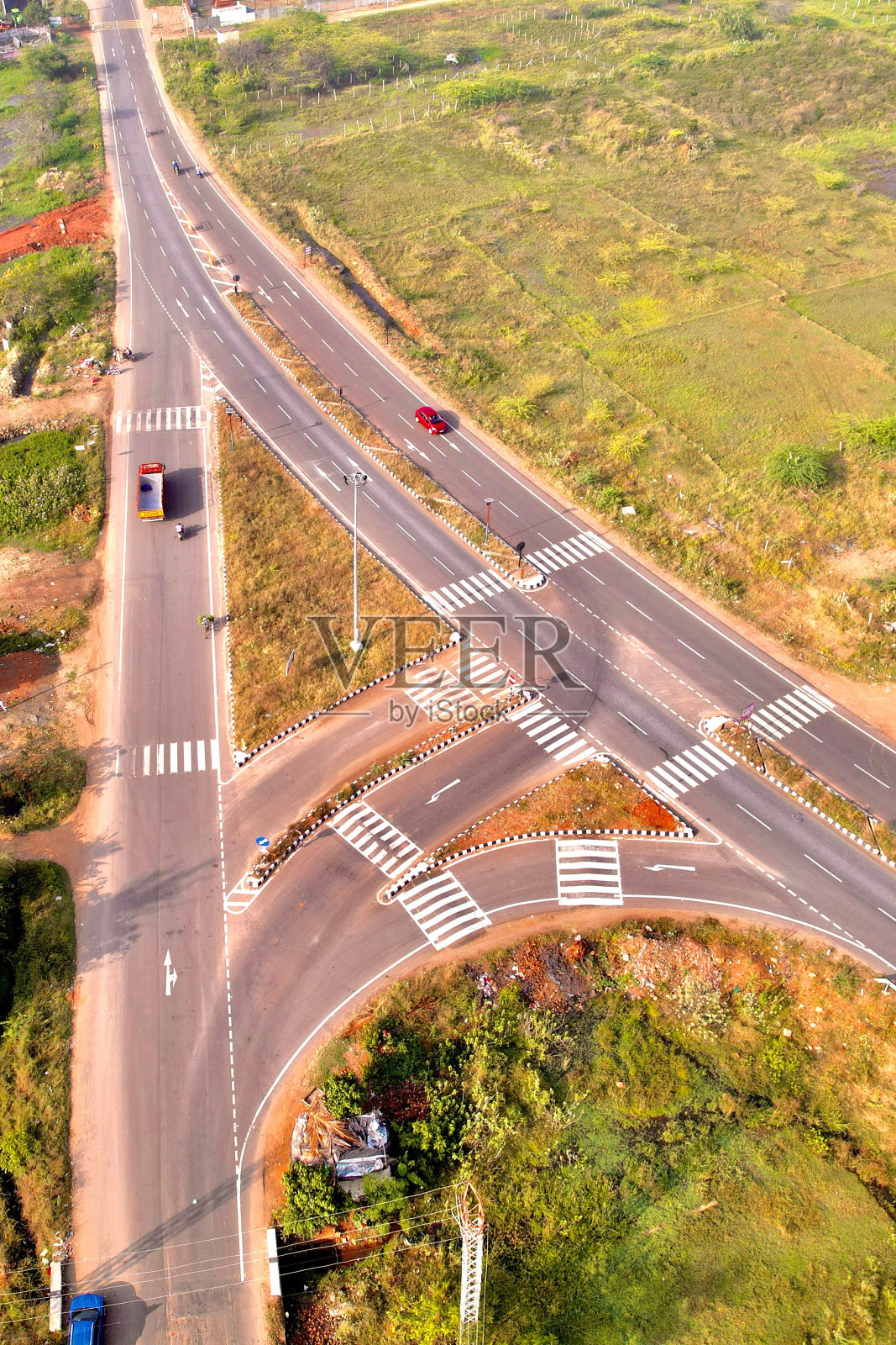 垂直无人机拍摄的汽车在柏油路周围的绿色田野照片摄影图片