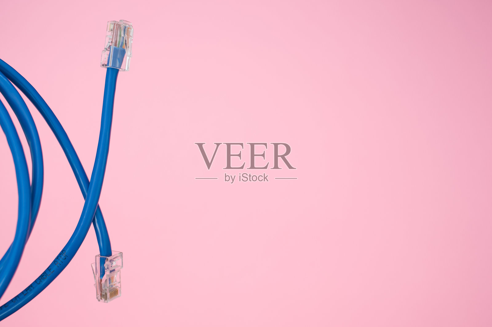 一个蓝色的局域网电缆孤立在粉红色的背景特写照片摄影图片