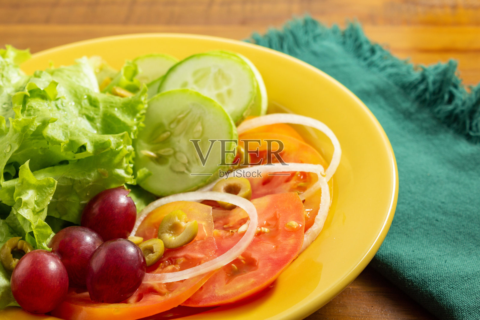 沙拉在黄色的盘子里。照片摄影图片
