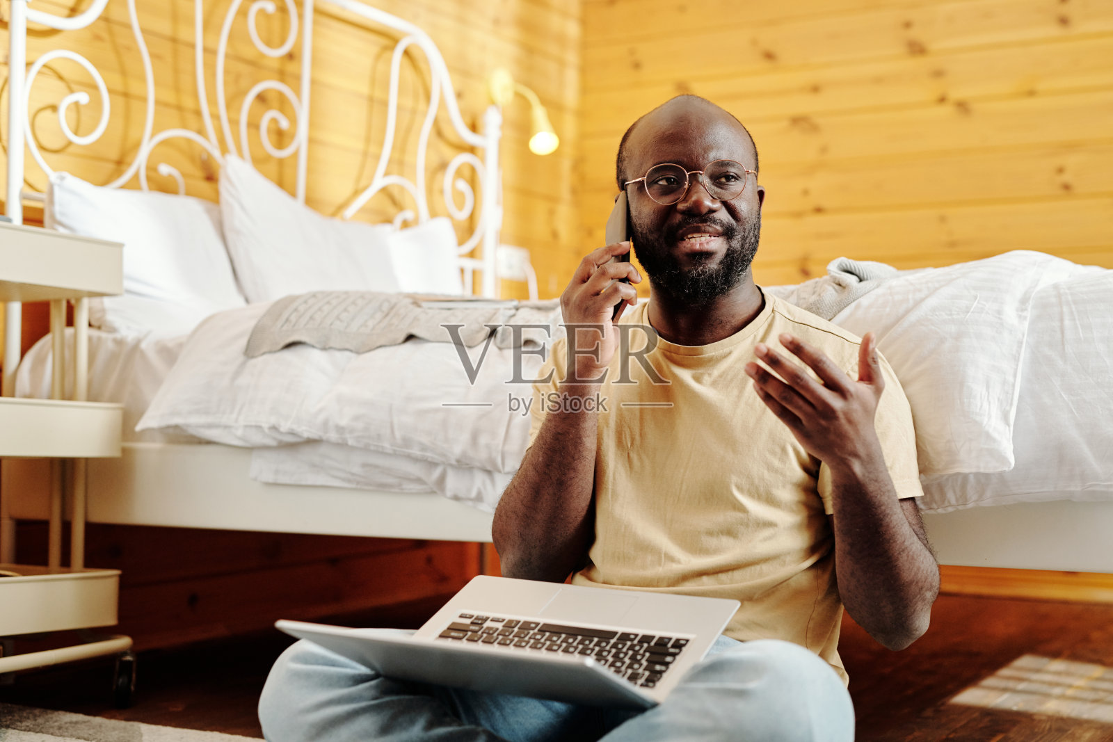 年轻自信的男性自由职业者在家里用智能手机说话照片摄影图片