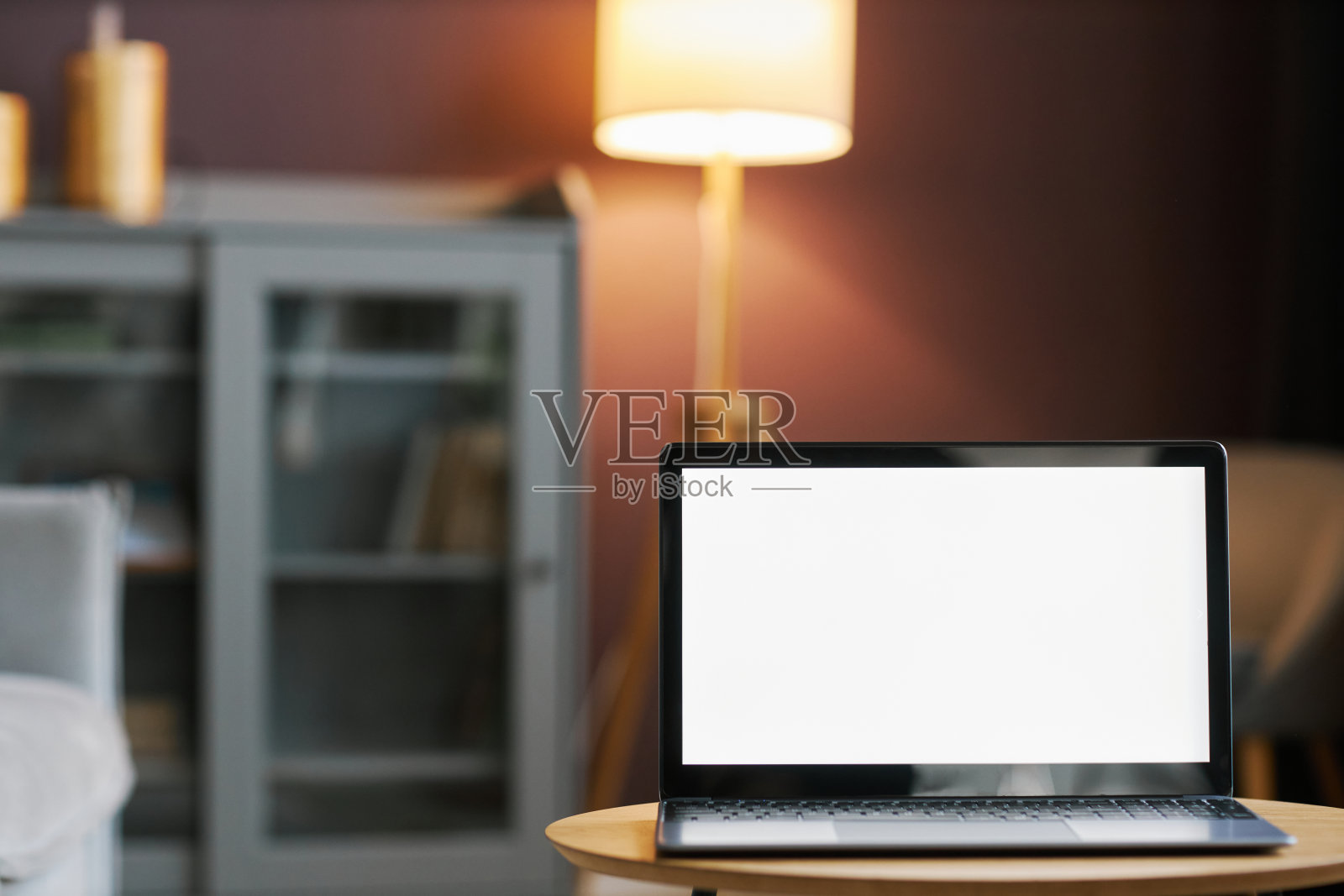 打开笔记本电脑与白色屏幕模型在舒适的家庭内部对淡紫色的墙照片摄影图片