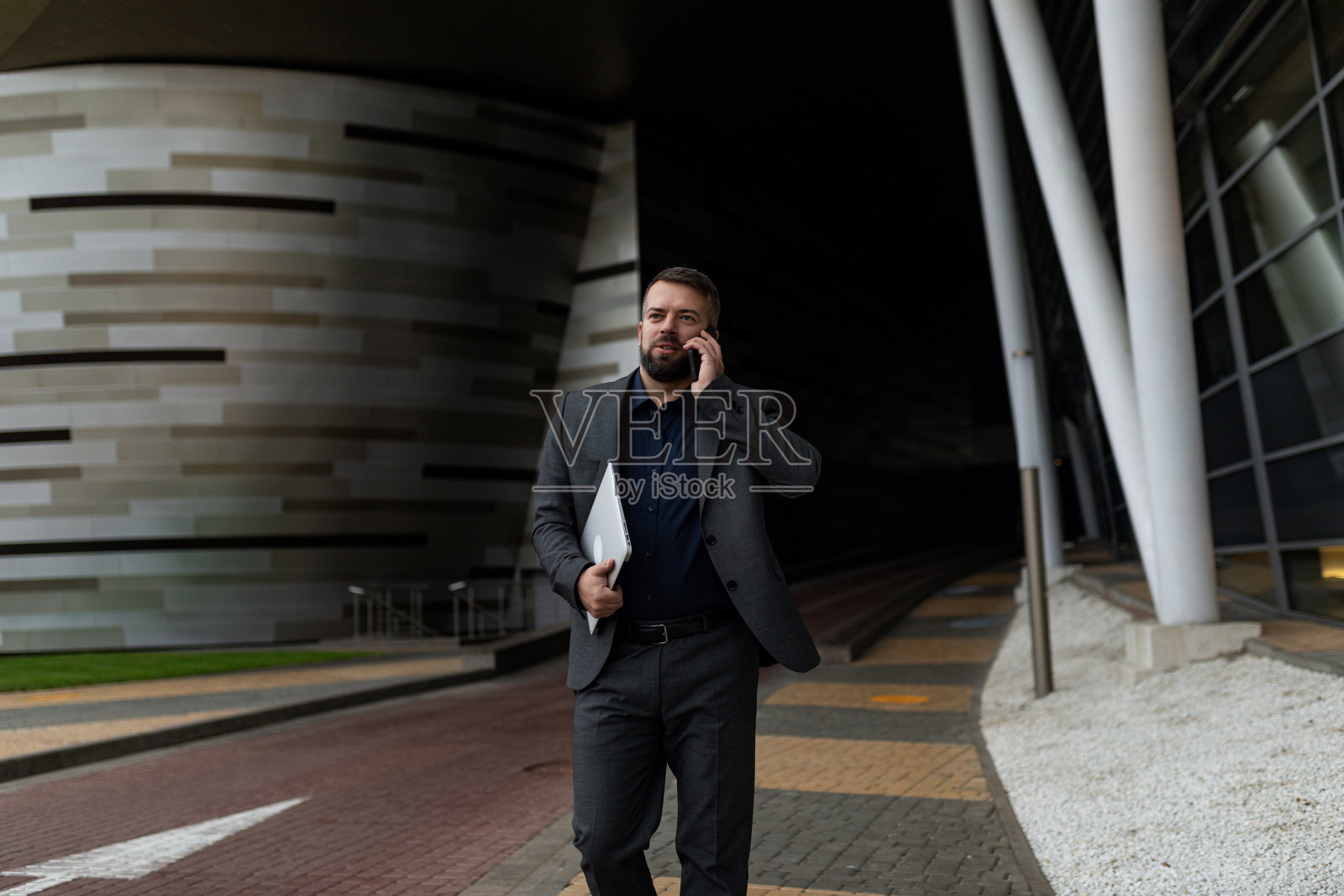 商人冲过来接他，手里拿着笔记本电脑打电话照片摄影图片