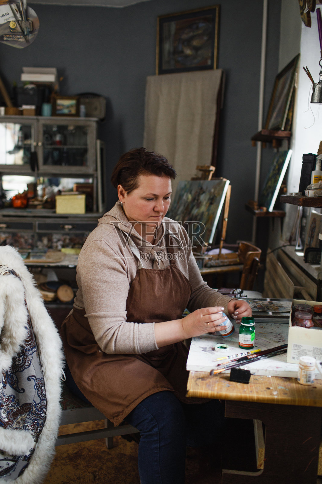 艺术家在她的工作室里为未来的绘画选择颜料。照片摄影图片