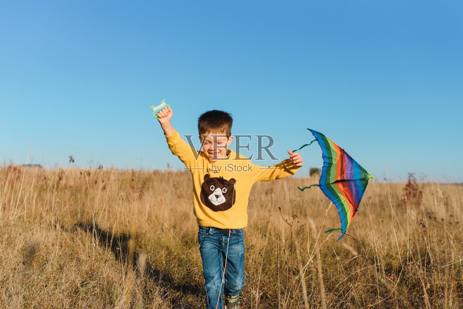小男孩头上放着风筝照片摄影图片