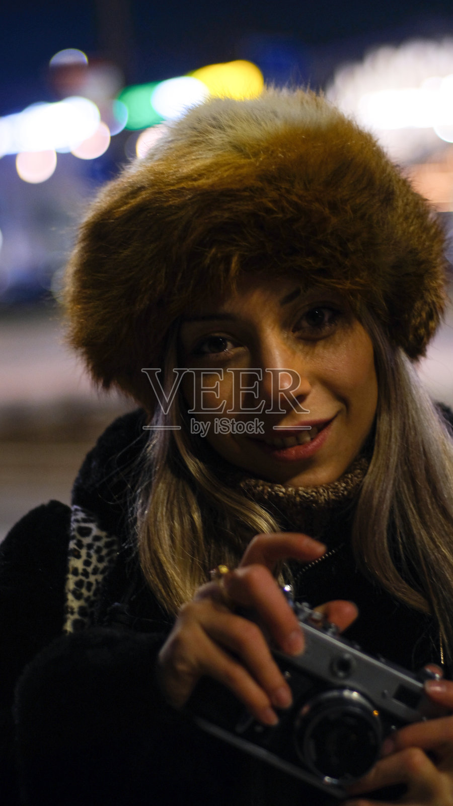 年轻女子在街上用模拟复古相机拍照照片摄影图片