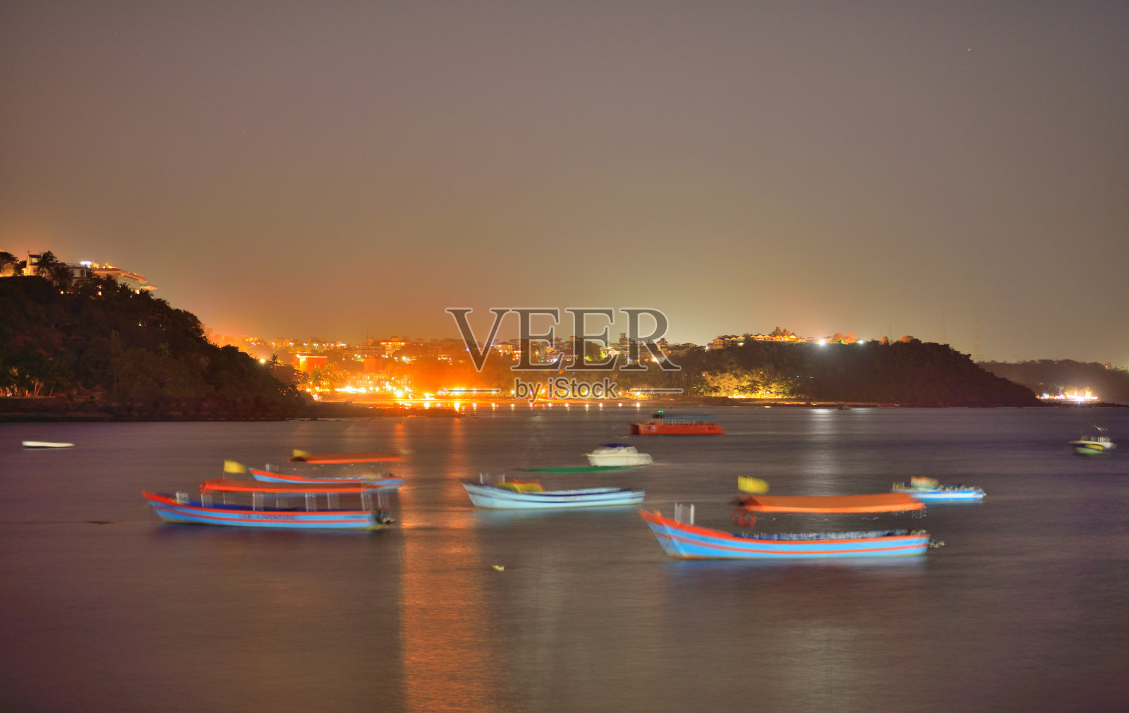 夜晚在果阿邦帕纳吉的Dona Paula观景台航行的船只。照片摄影图片