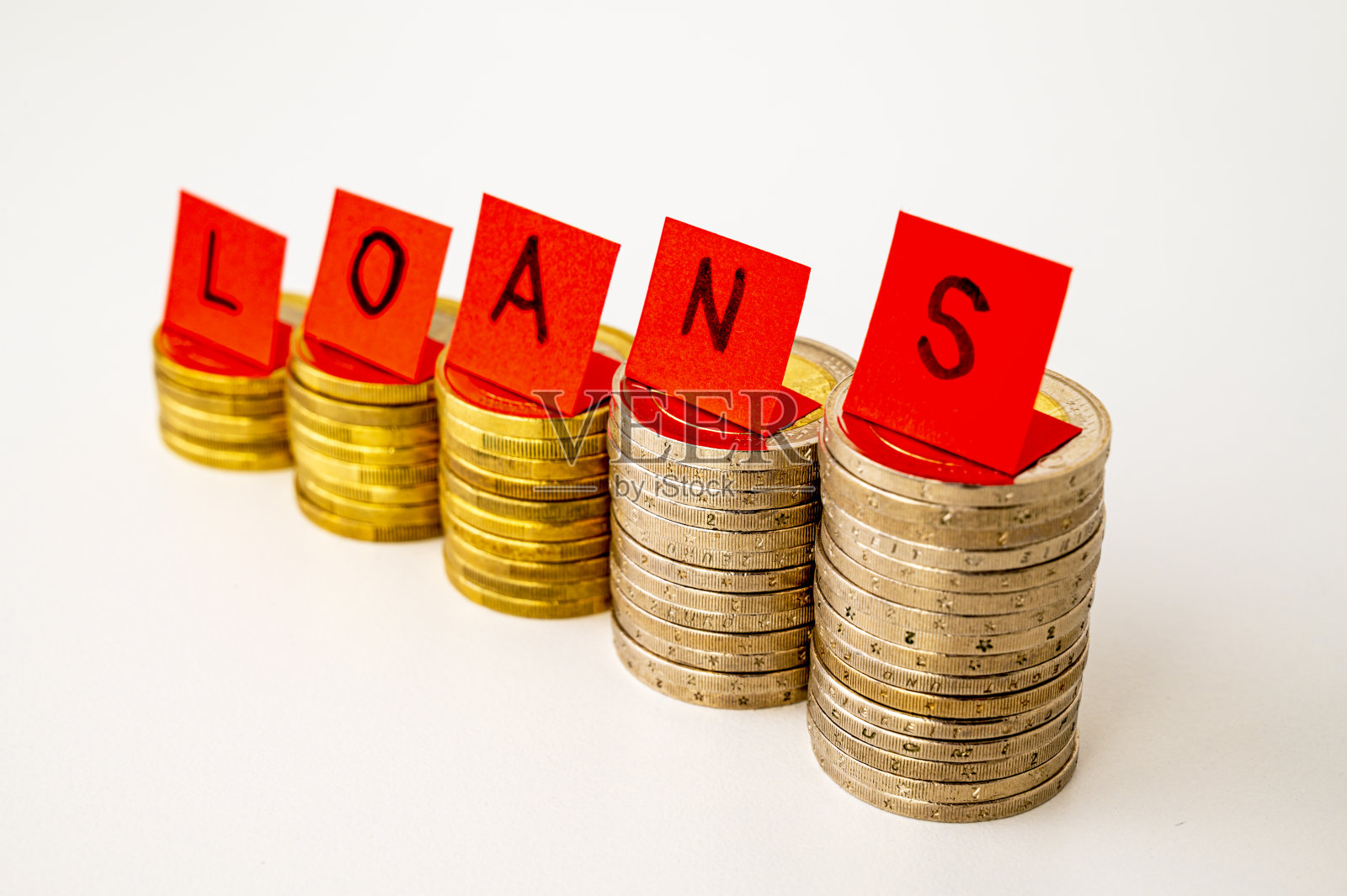成堆的硬币和文字“贷款”。抵押贷款增加。照片摄影图片