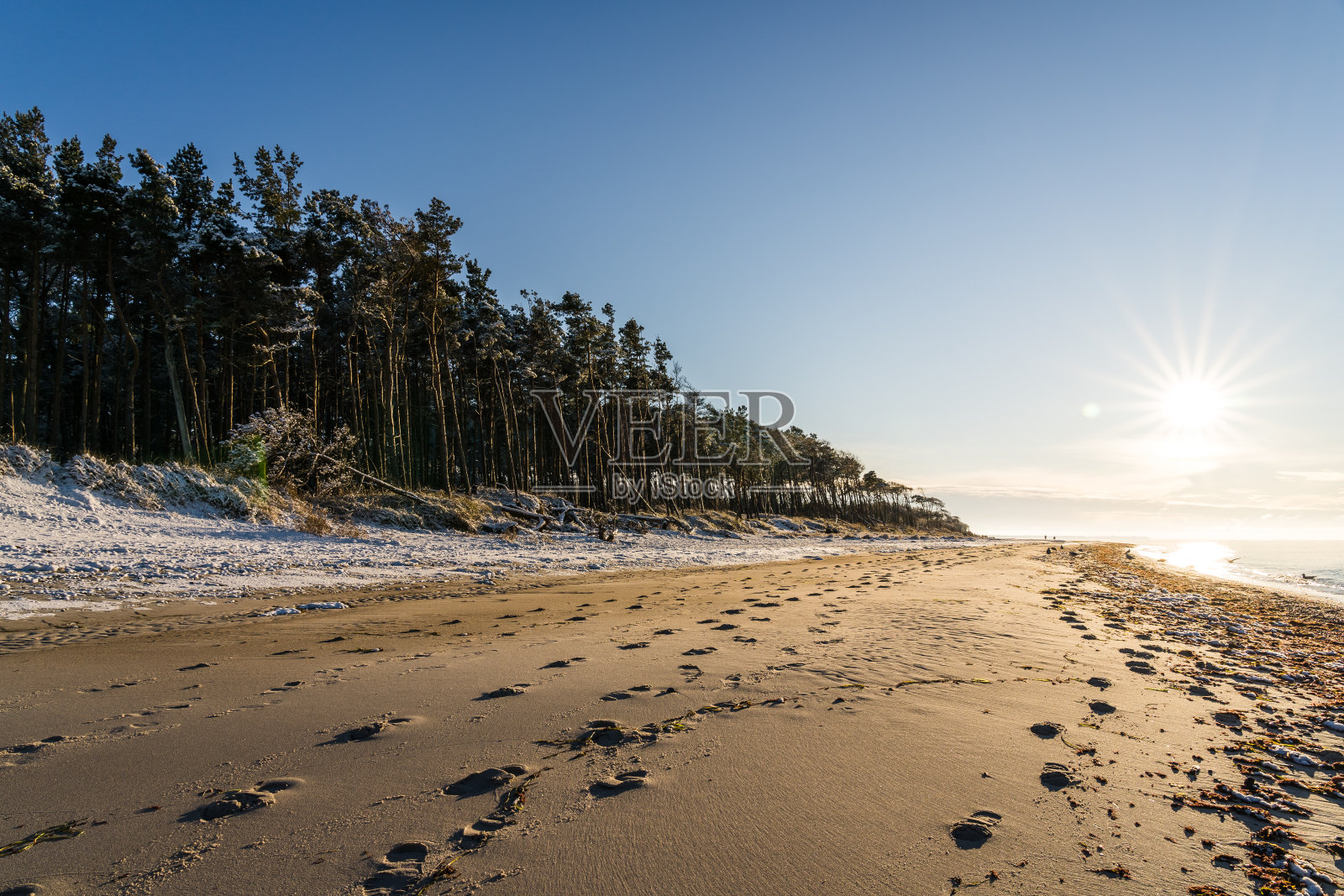 阳光明媚的冬日，在德国达斯岛著名的西岸海滩，前景中有脚印照片摄影图片