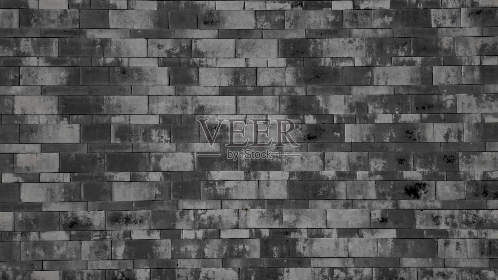 水泥混凝土路面有不规则的灰色斑点。每个方格有两种尺寸的瓷砖。廉价的纹理从高处俯视，棕色，砂岩，砖照片摄影图片