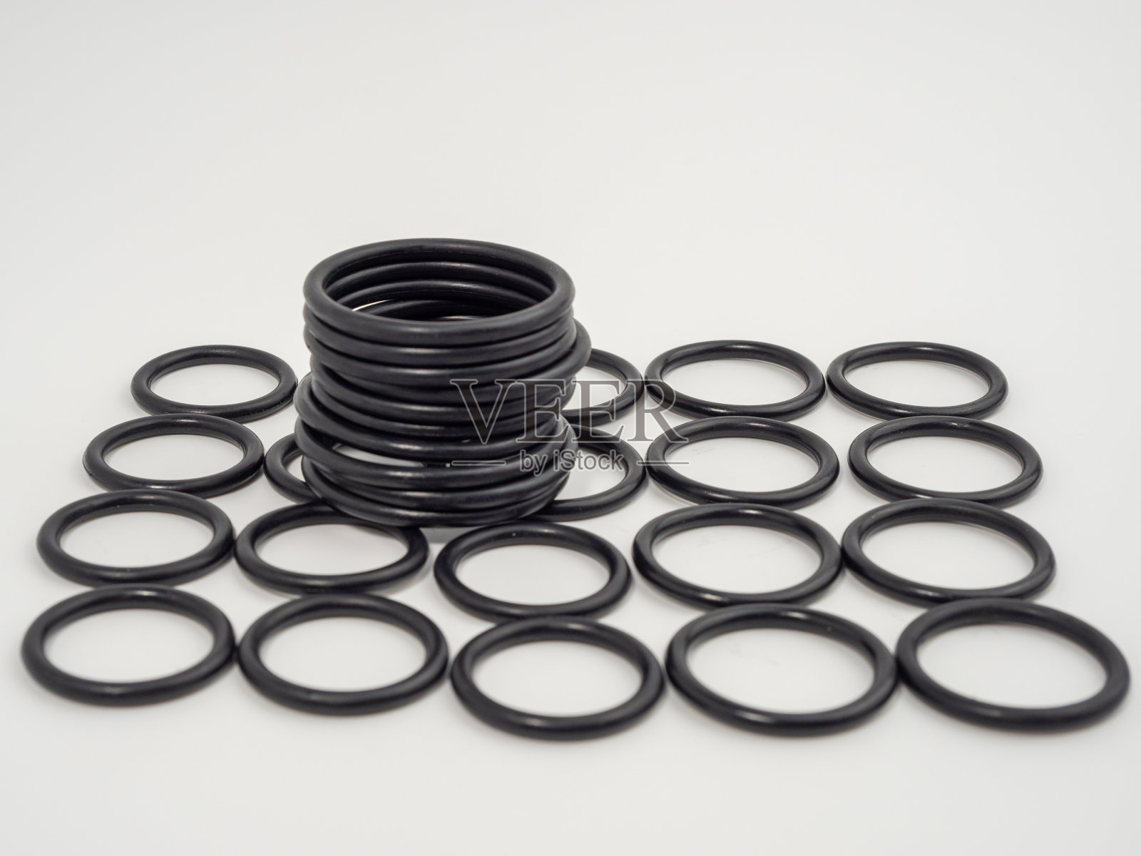 白色背景上不同尺寸的黑色液压和气动o形环。管道用橡胶垫圈。照片摄影图片