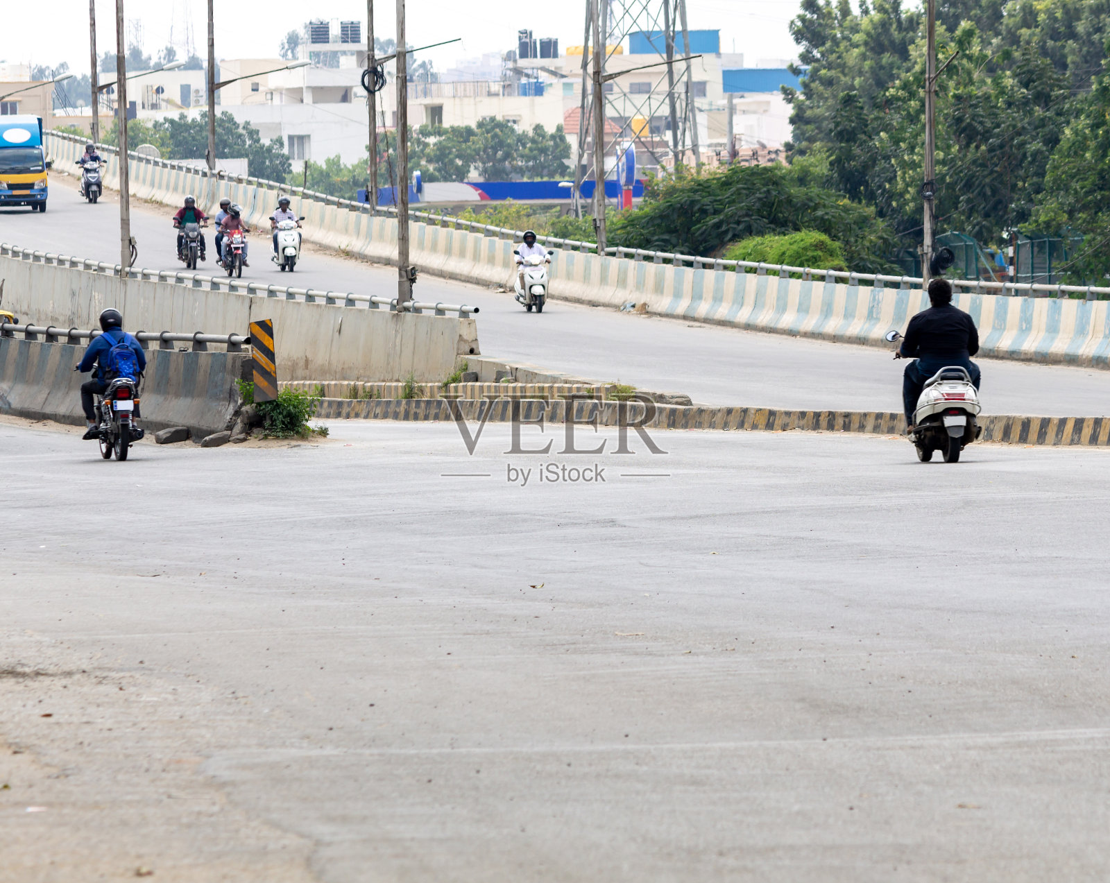 在印度一个阴沉的日子里，交通道路上有移动的车辆和摩托车手照片摄影图片
