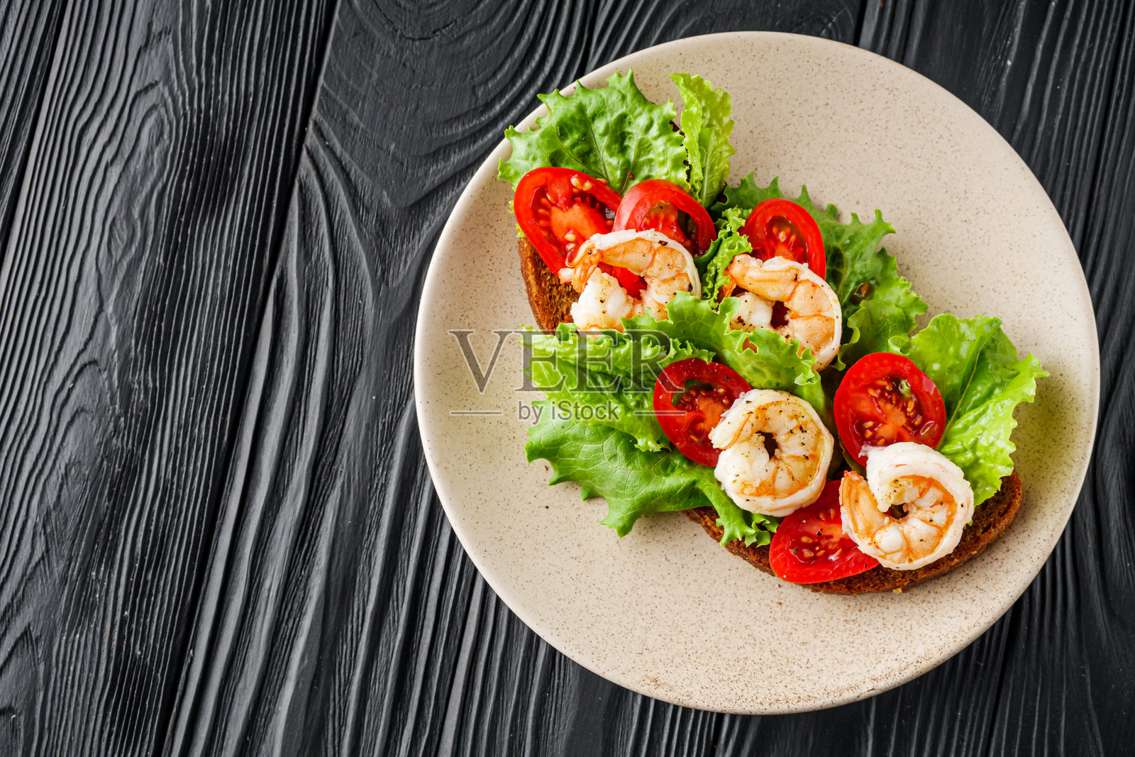 美味的意大利意式烤面包，黑色的木制乡村背景上有虾仁照片摄影图片