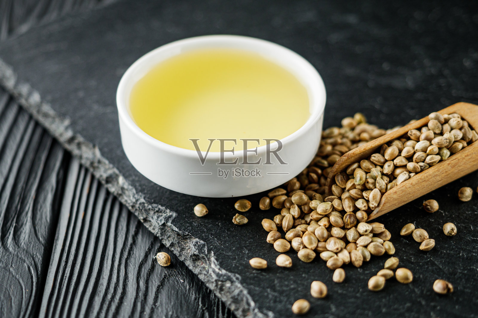 天然大麻籽精油在黑色的石头背景照片摄影图片