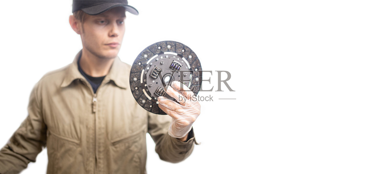 男性汽车机械师与套件的新离合器盘在白色背景。照片摄影图片
