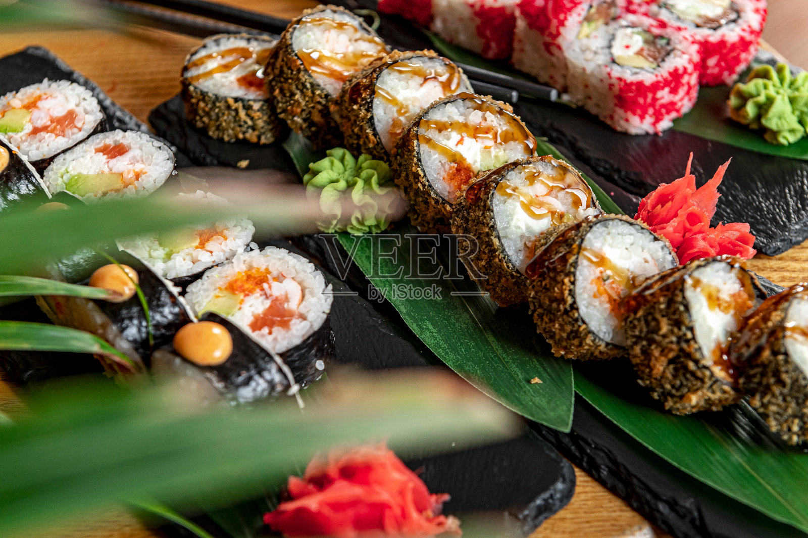 一整套亚洲食物。深色背景上的寿司和面包卷。照片摄影图片