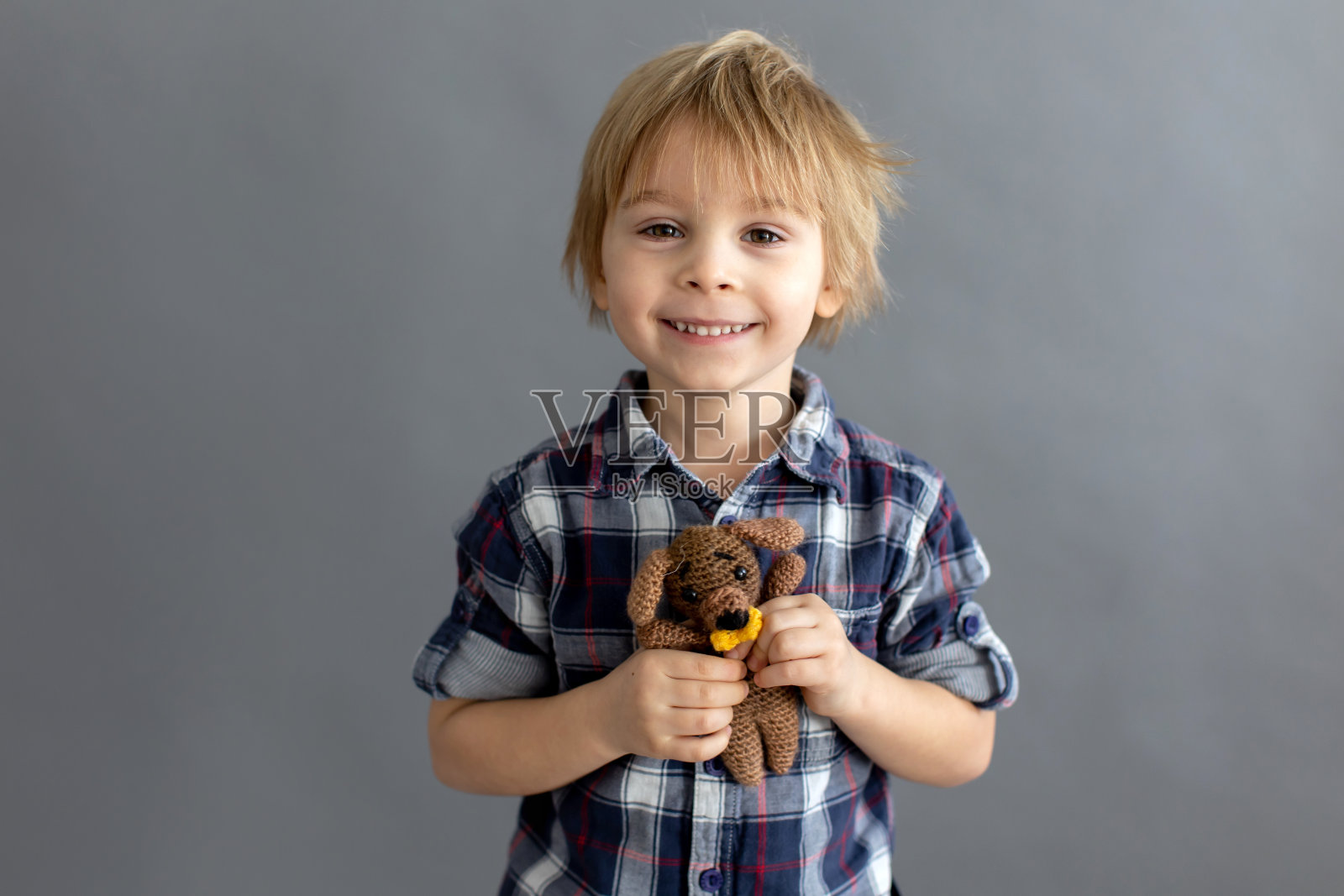 小蹒跚学步的孩子，金发男孩，玩手工编织的小玩具照片摄影图片