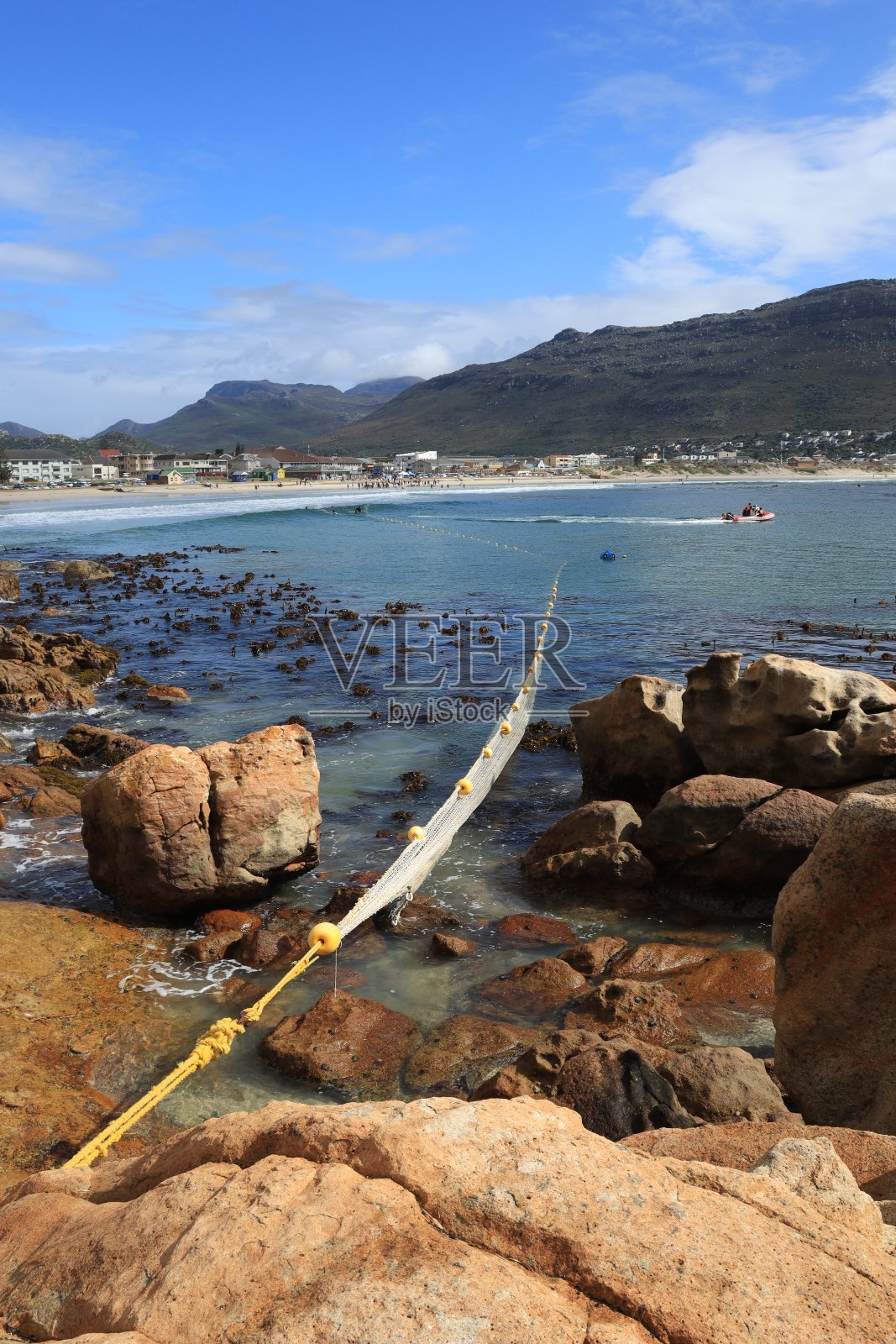 蓝色海洋的垂直镜头，山的背景上有一张网照片摄影图片