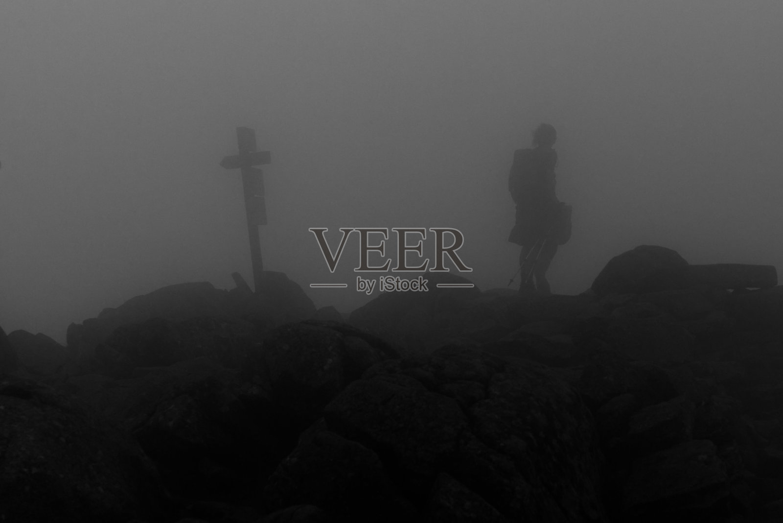 在一个阴沉的日子里，一个人在十字雕像附近的灰度镜头照片摄影图片
