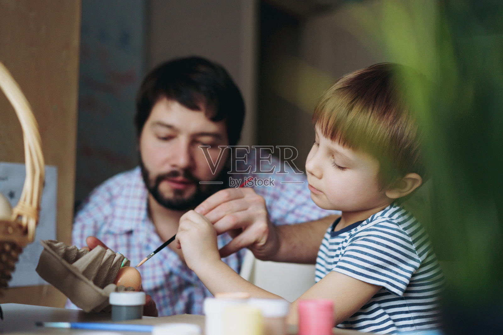 父亲和孩子为复活节画彩蛋照片摄影图片