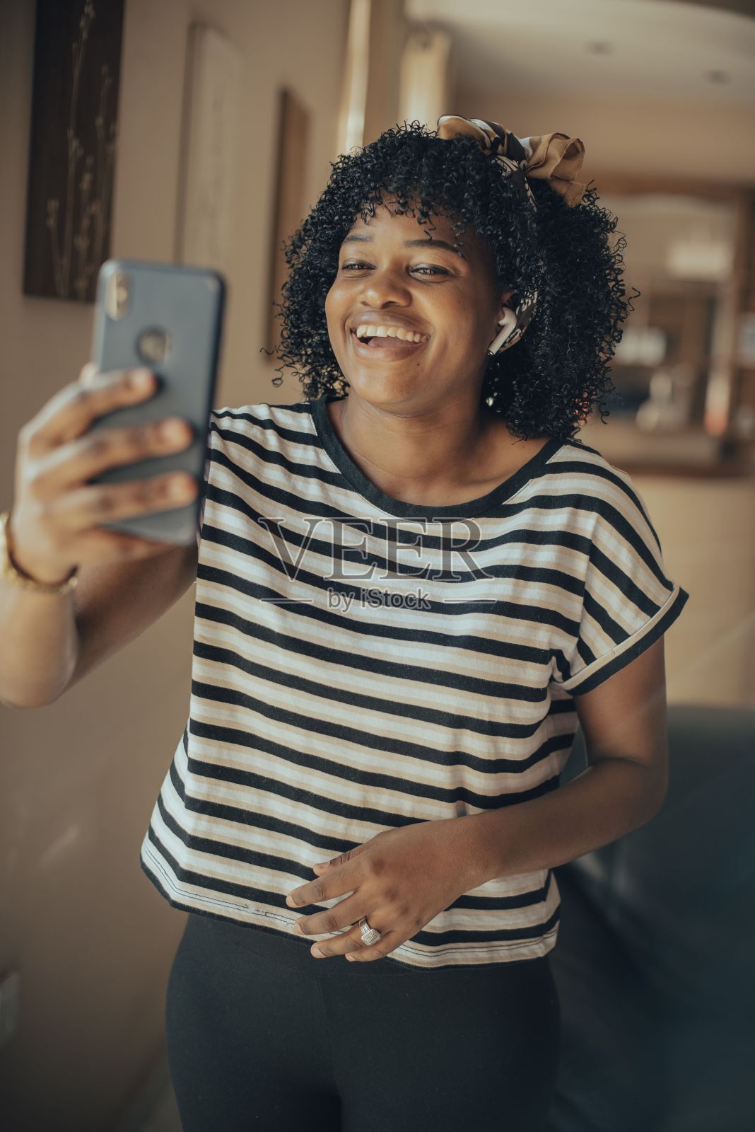 垂直拍摄一名年轻女性戴着无线耳机打电话照片摄影图片