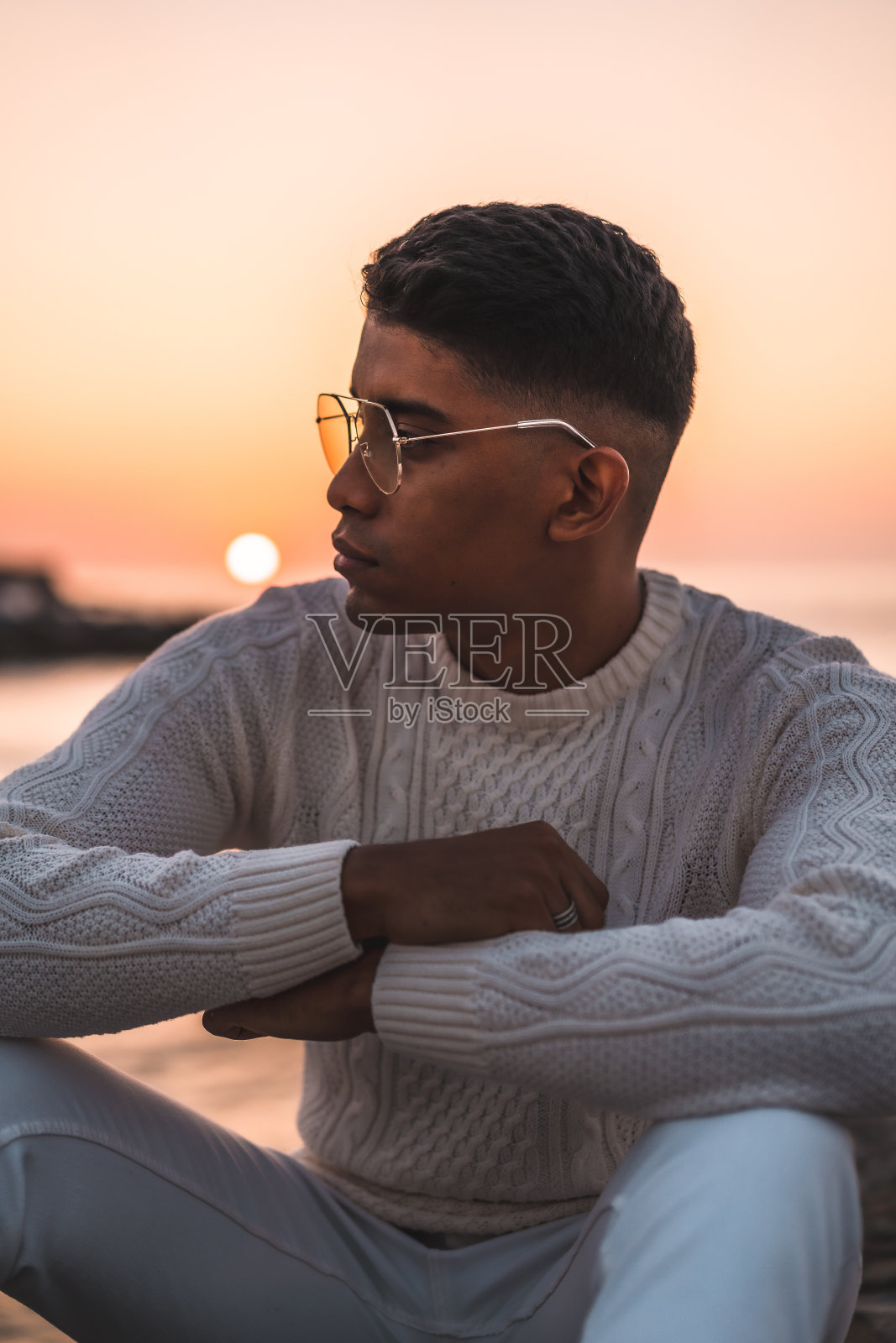 英俊的西班牙人坐在日落时享受暑假照片摄影图片