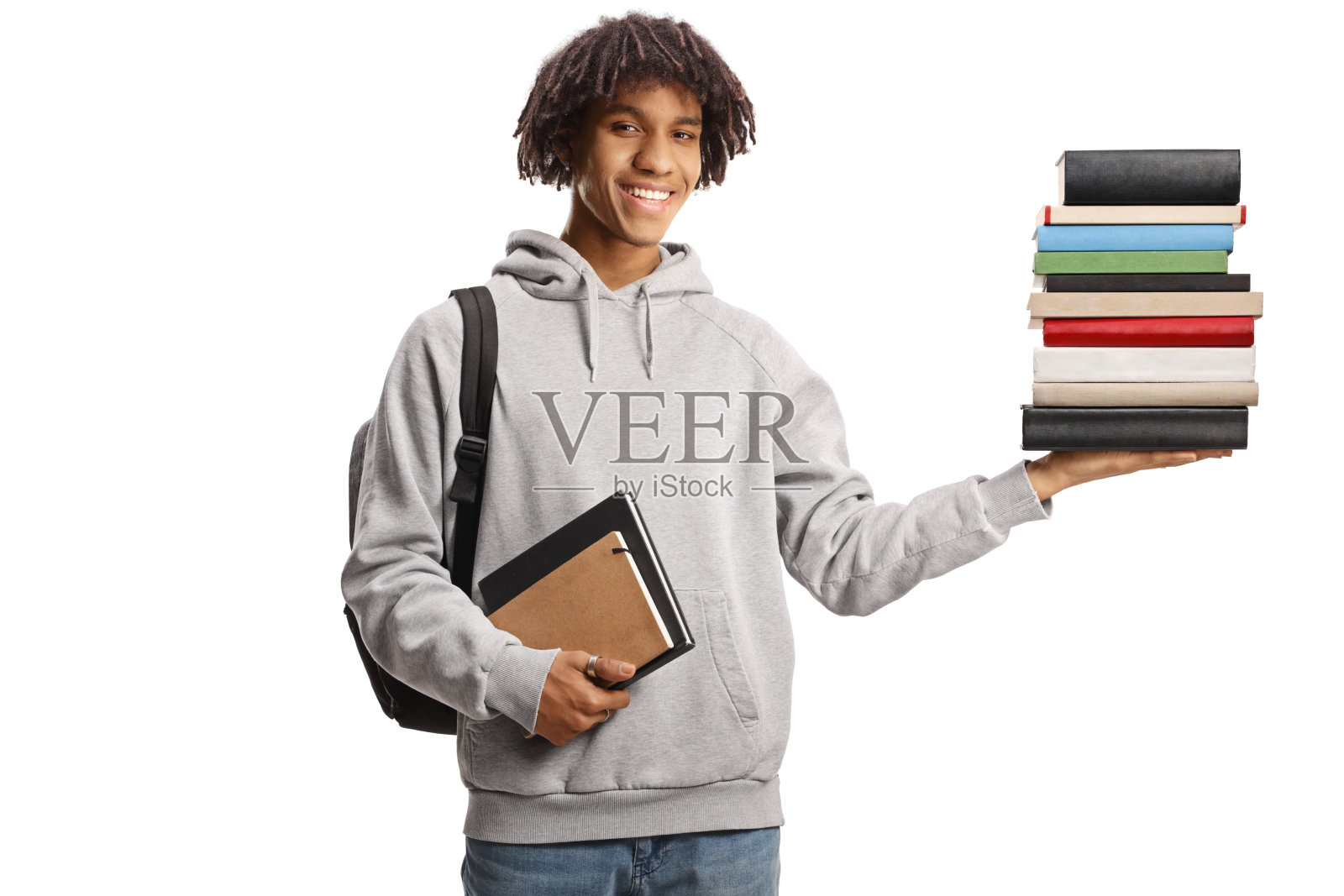 年轻的非裔美国男子背着背包，手里拿着一堆书照片摄影图片