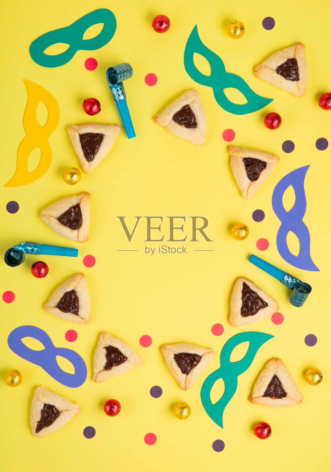 哈曼塔臣饼干，狂欢节面具，黄色背景上的噪音制造者。普珥节庆祝，犹太狂欢节假日概念。照片摄影图片