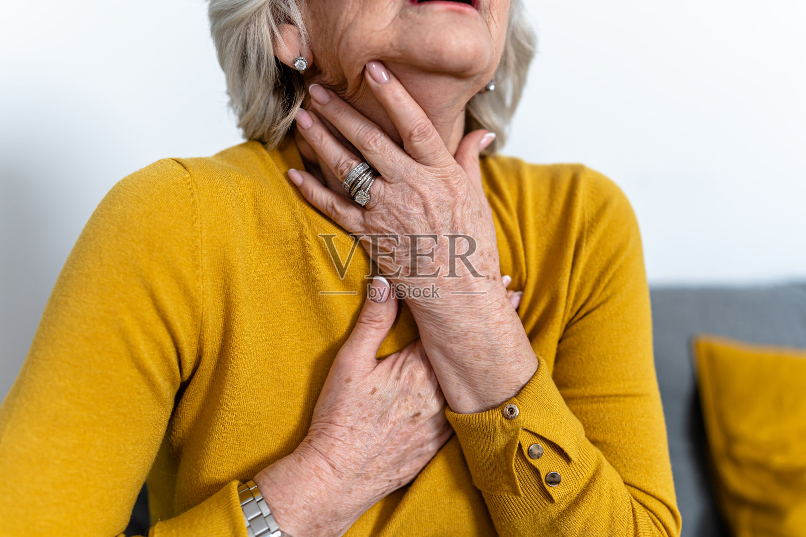 患有慢性疾病的老年妇女因喉咙哽咽和疼痛而感到绝望照片摄影图片