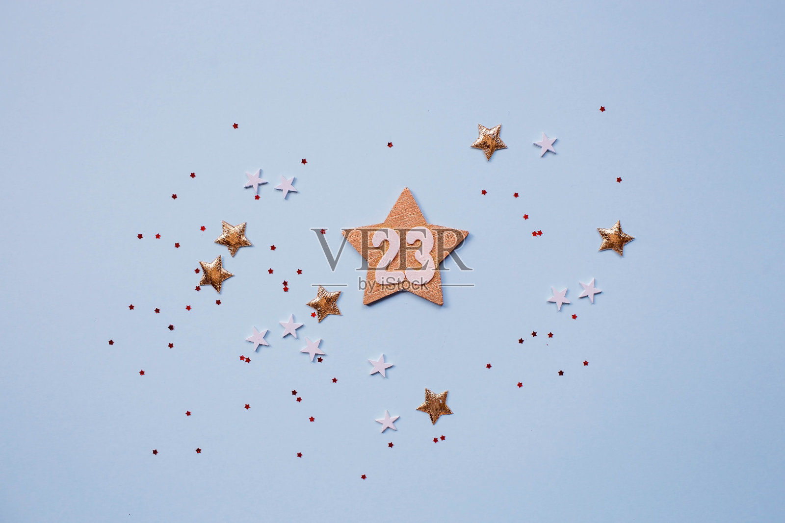 给祖国保卫者节的贺卡。白色、金色、红色的星星和浅蓝色背景上的数字23。假期是2月23日。照片摄影图片