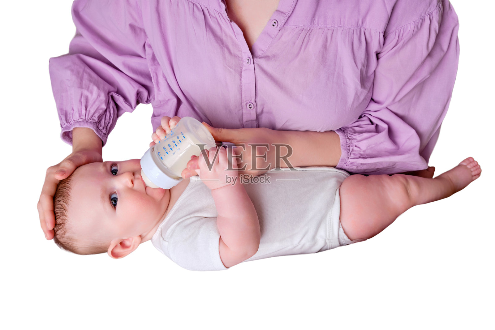 一位母亲用白色背景的奶瓶喂婴儿配方奶粉。六个月大的孩子照片摄影图片