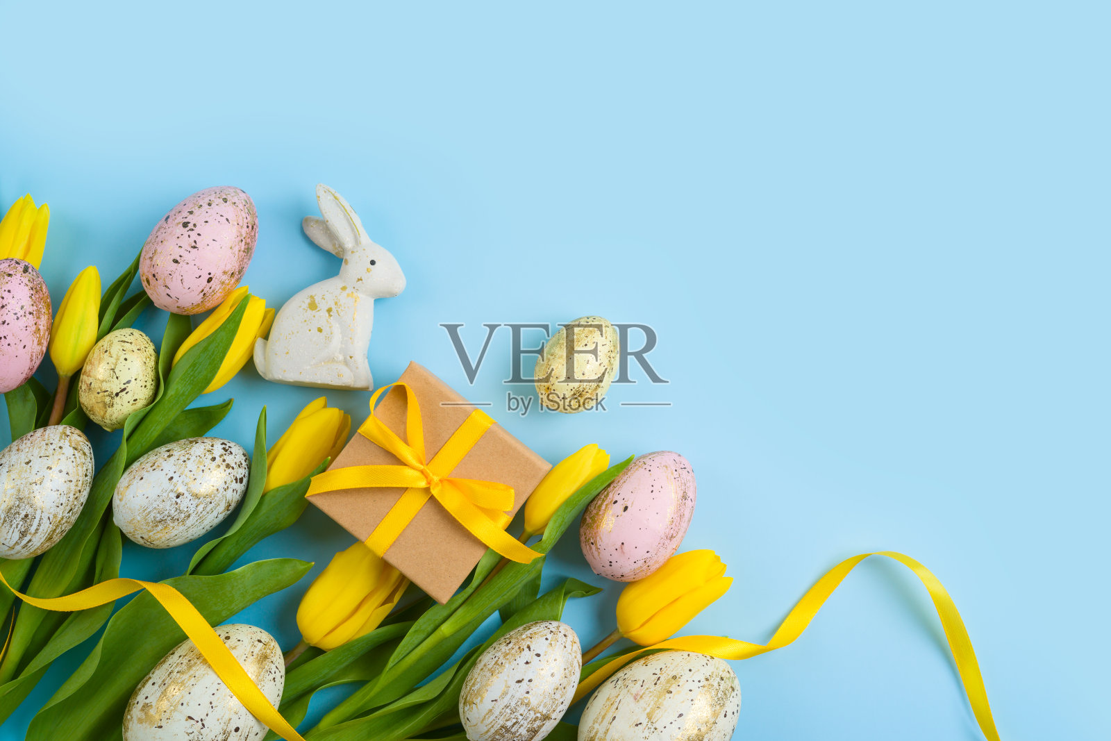 复活节假期背景与复活节彩蛋，礼盒和黄色郁金香花。俯视图，平面布局照片摄影图片
