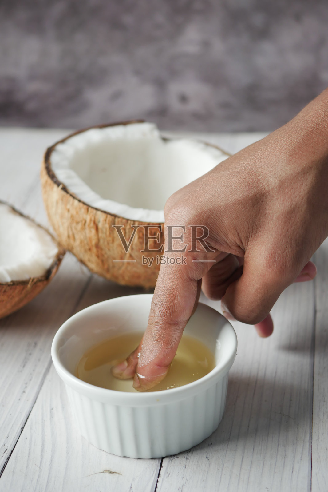 桌上放着一片新鲜的椰子和一瓶油照片摄影图片