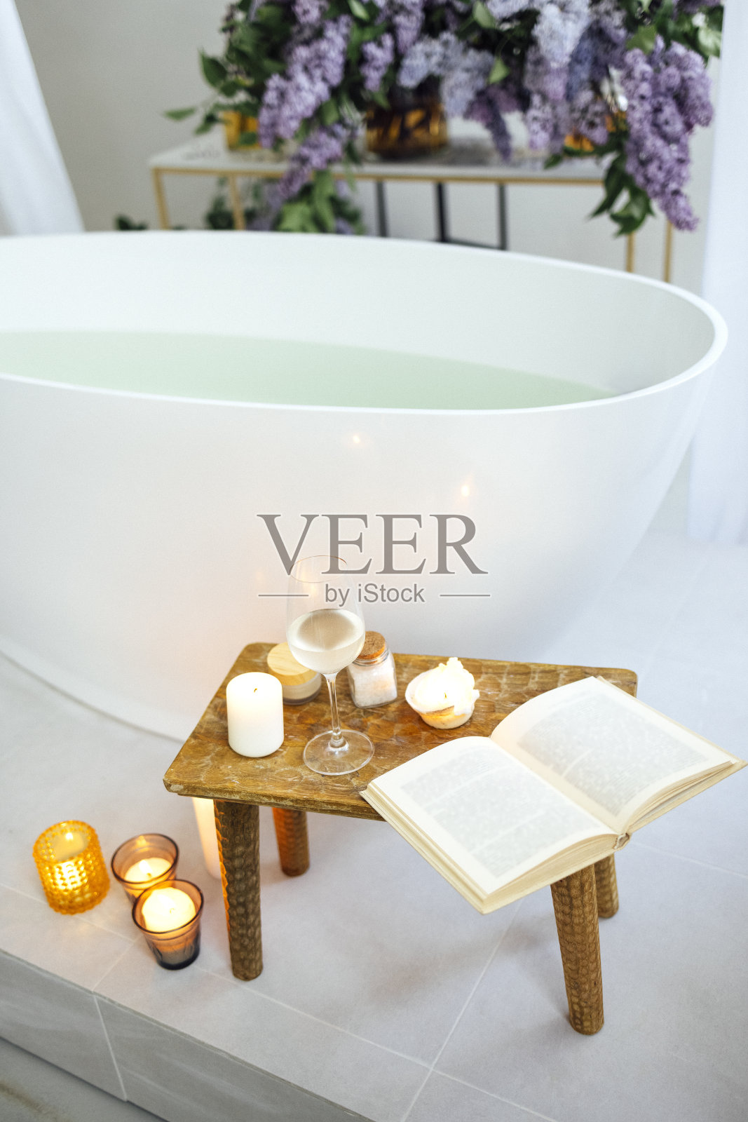 现代浴室和水疗中心的白色浴缸木桌。照片摄影图片