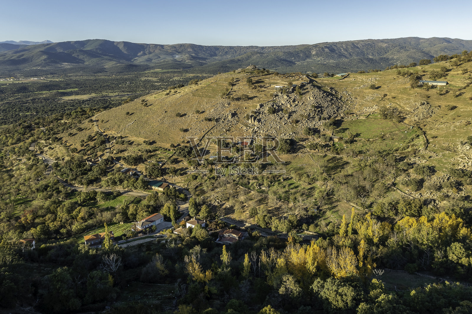 无人机在西班牙埃斯特雷马杜拉拍摄Segura de Toro村的秋季景观，沿途有道路、树木、植物和岩石。照片摄影图片
