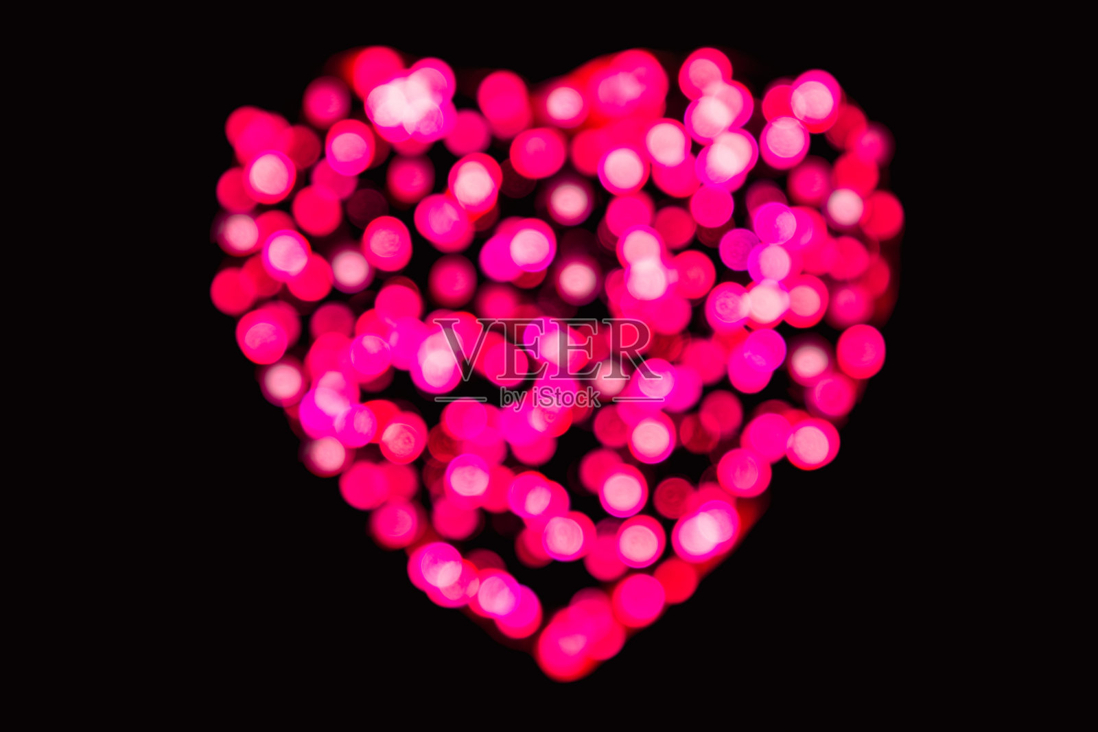 离焦品红色纸屑，黑色背景心形(情人节背景)照片摄影图片