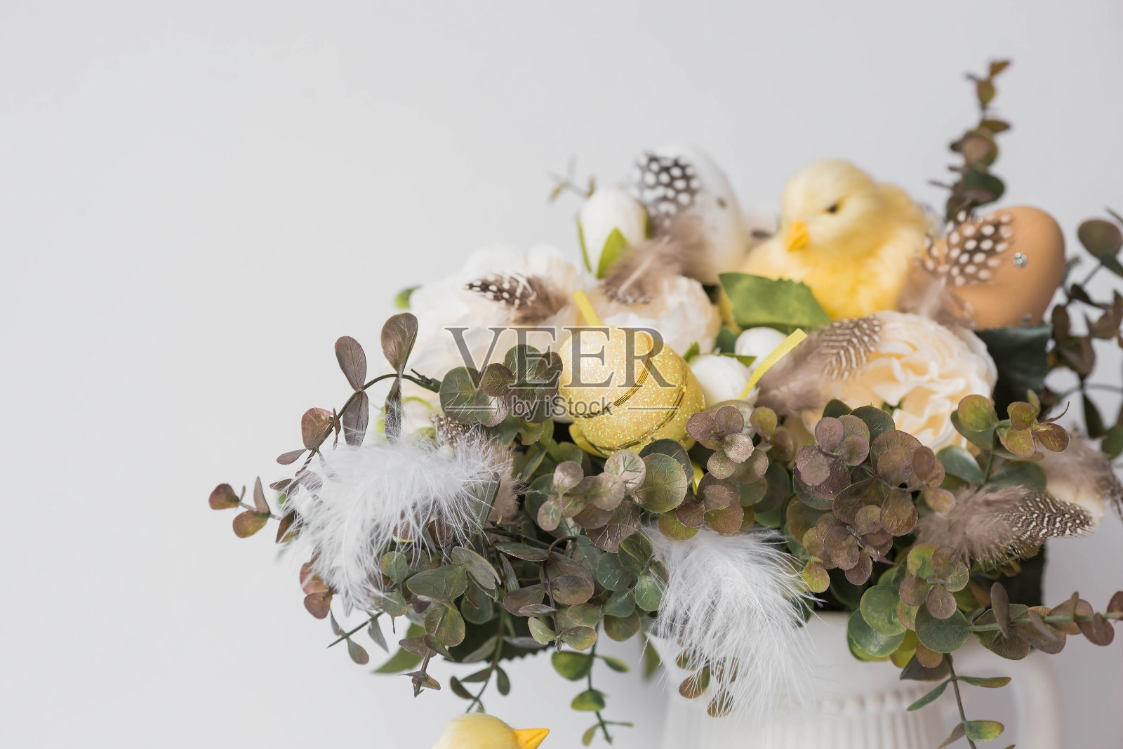 横幅。一个明亮的复活节假期的概念。白色背景上有羽毛、黄色鸡和复活节鹌鹑蛋的花束。漂亮的复活节卡片。照片摄影图片