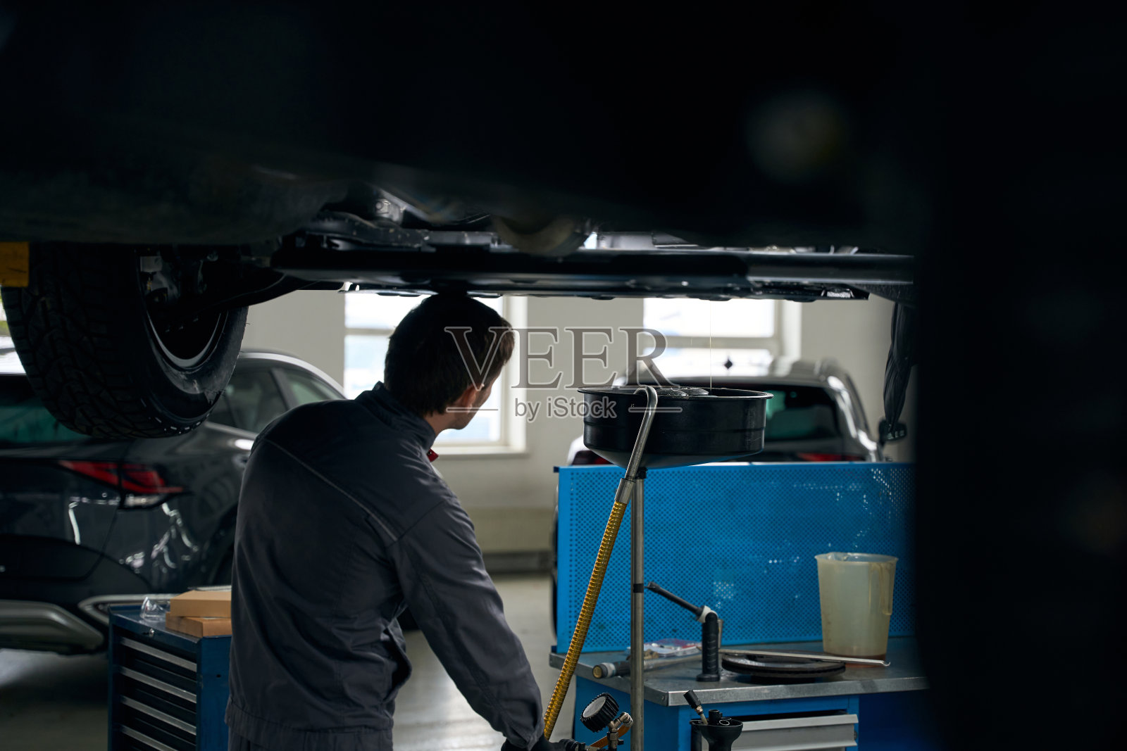 维修工在修理前准备汽车，清除发动机油照片摄影图片