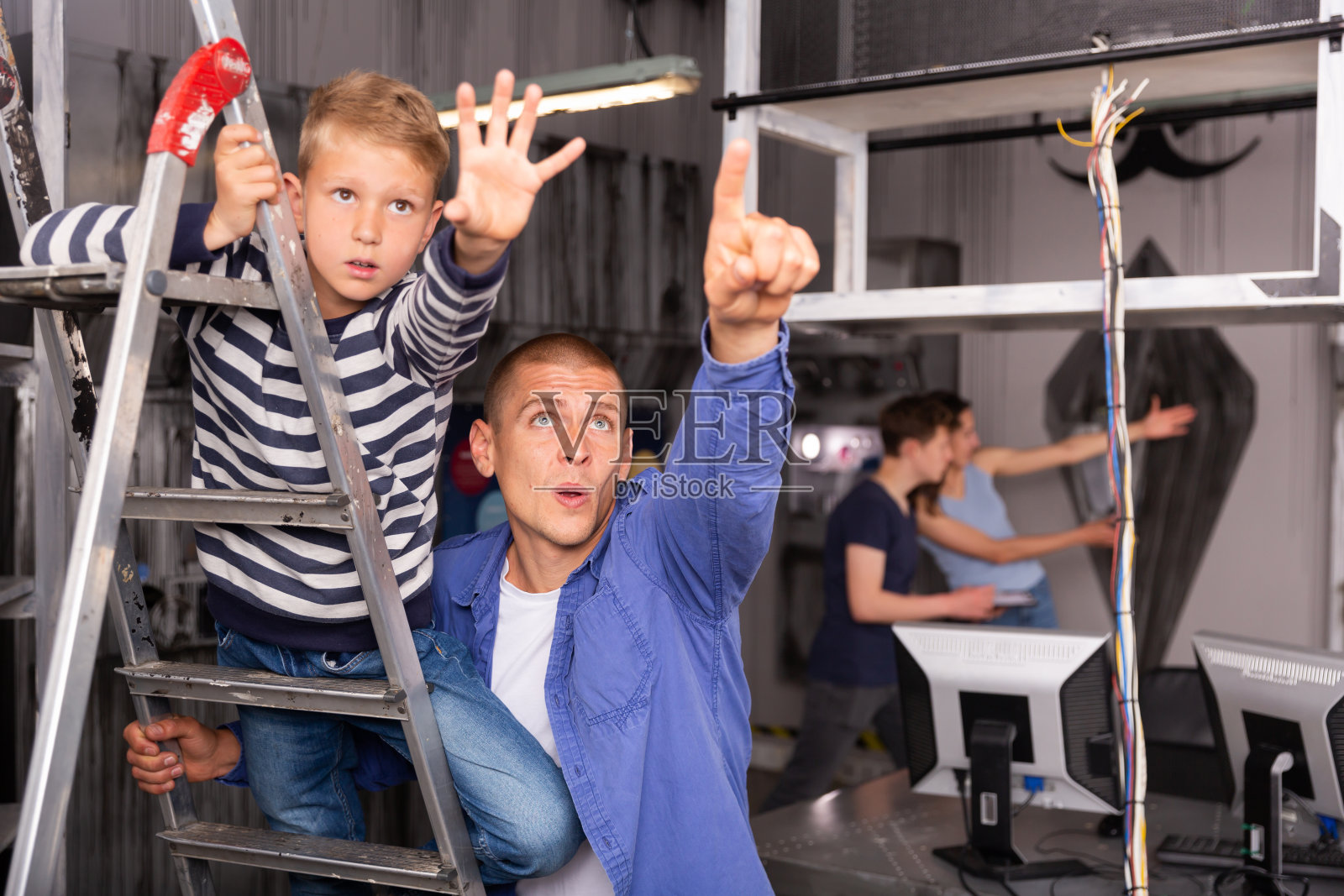 男孩和父亲在探索室里伸出手照片摄影图片