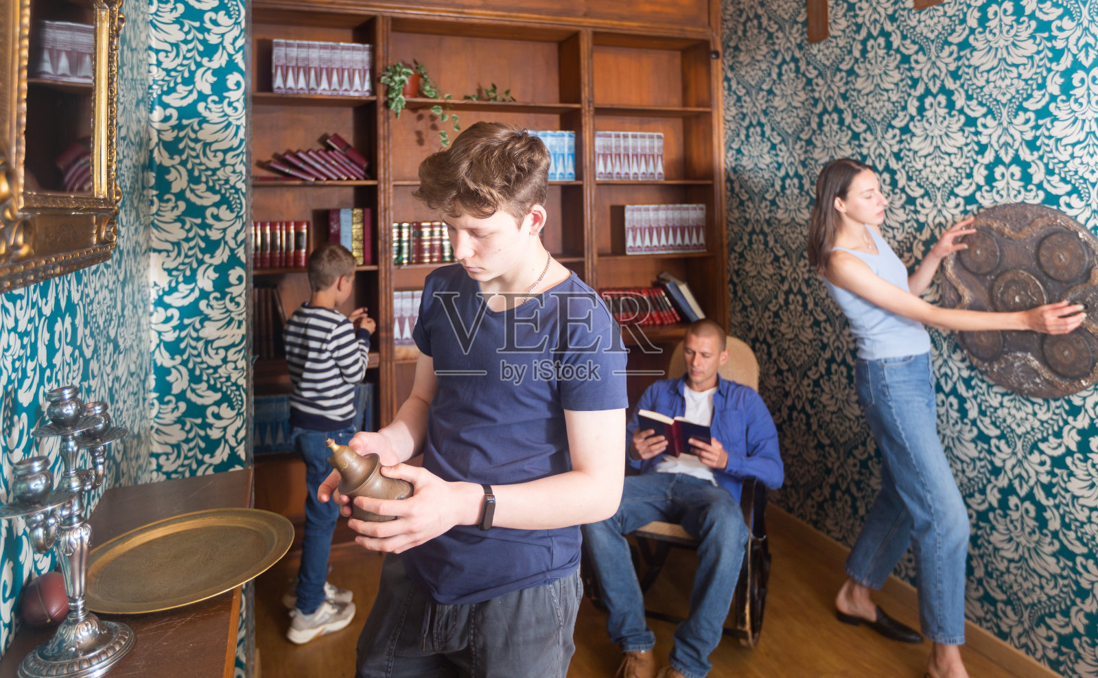 专注的少年在探索室检查古代水壶照片摄影图片